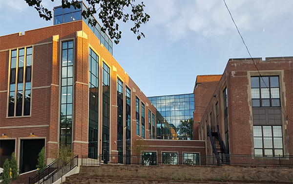 The design of the addition (left) respects the Collegiate Gothic style architecture of the original facility (right). A glass bridge connects new and old.