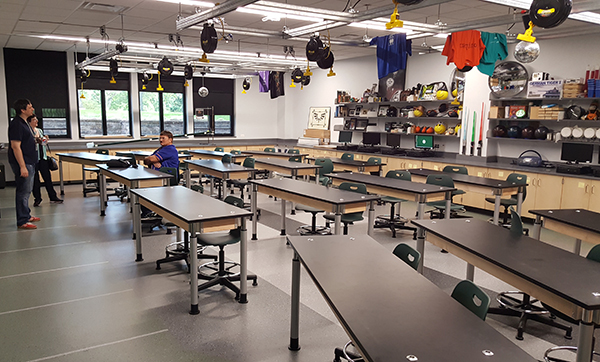 A physics lab features adjustable tables, a ceiling system for hanging experiments, retractable power reels, magnetic boards, and a dual-shade system.