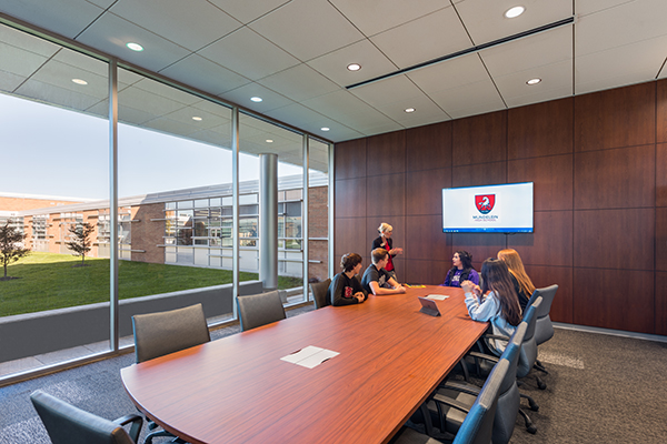 Students meet with business mentors in a large conference room across from the Business Incubator.