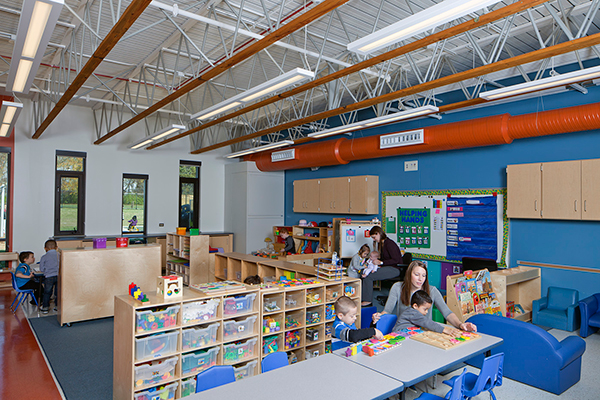 Classrooms at Addison Early Learning Center offer a corner reading zone with a window and small cabinets that children can crawl under, a cubby zone for personal items, and a wet zone with a sink.