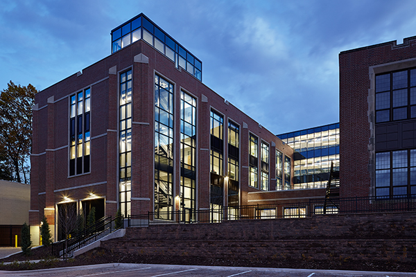 Nighttime view into the science addition (left) and glass bridge (center) that connects to the existing school (right).