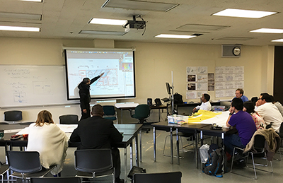 A student presents a floor plan during a collaborative design charrette.