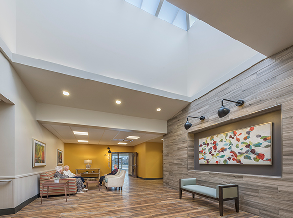 A skylight illuminates a gathering area at the end of a short-term rehab corridor.