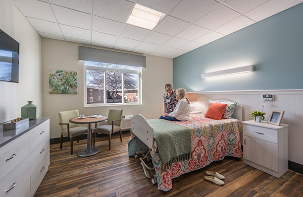 A patient room in the short-term care addition has views to a courtyard and a table for visitors.