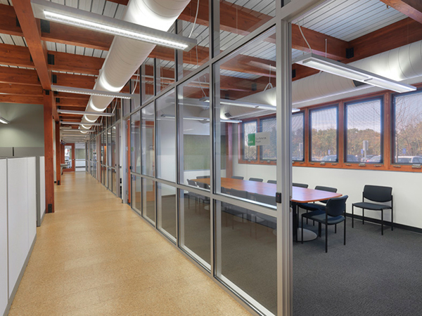 Natural light flows through a conference room and into the corridor at the JJC Facility Services Building.