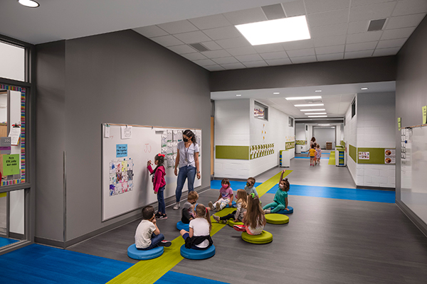 early learning corridor with teacher using whiteboard with students