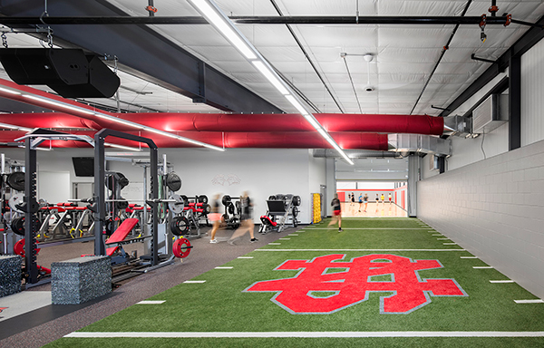 high school fitness center with artificial turf and weights