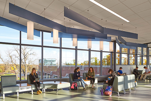 high school corridor with large windows and students working