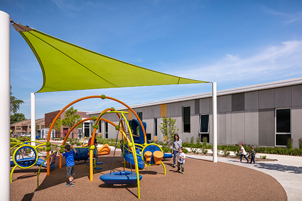 outdoor playground with school in background