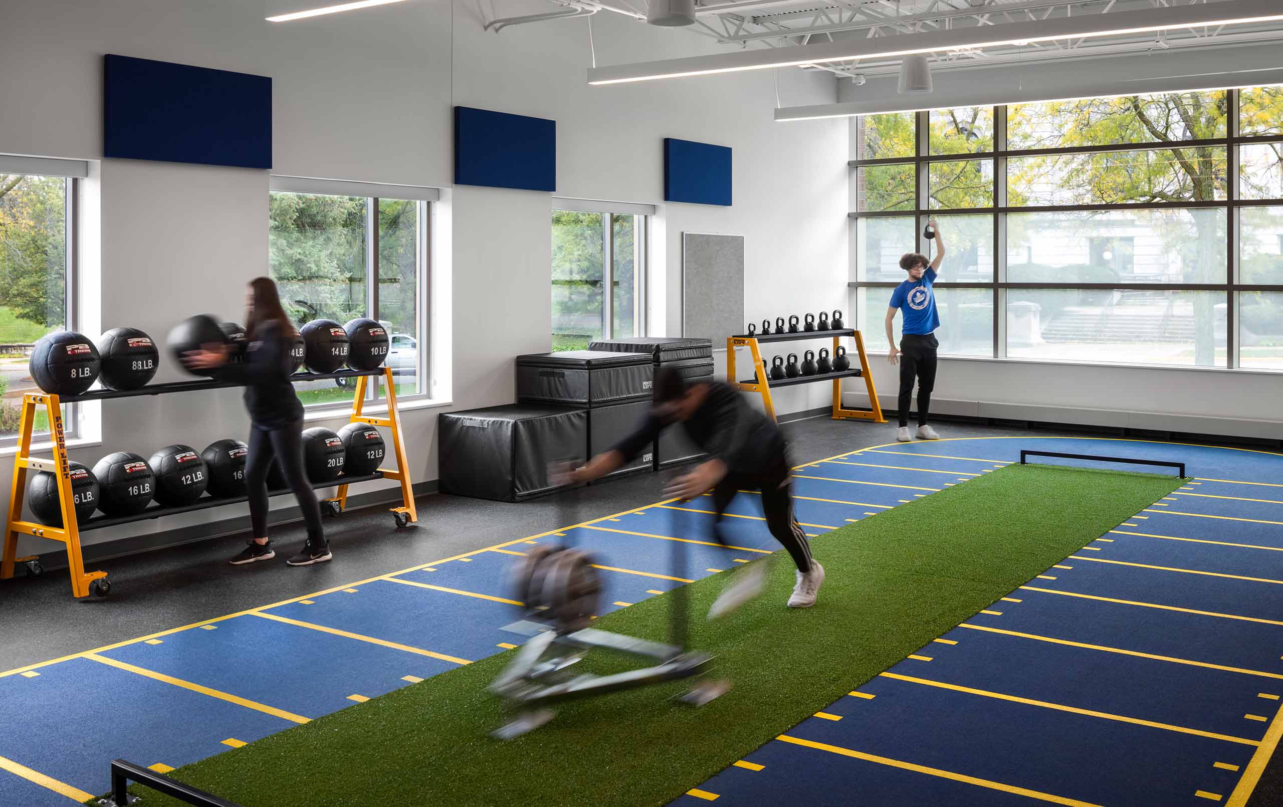 Three students training in the weight room at Peter. J. Lindberg, M.D. Center for Health and Human Performance.