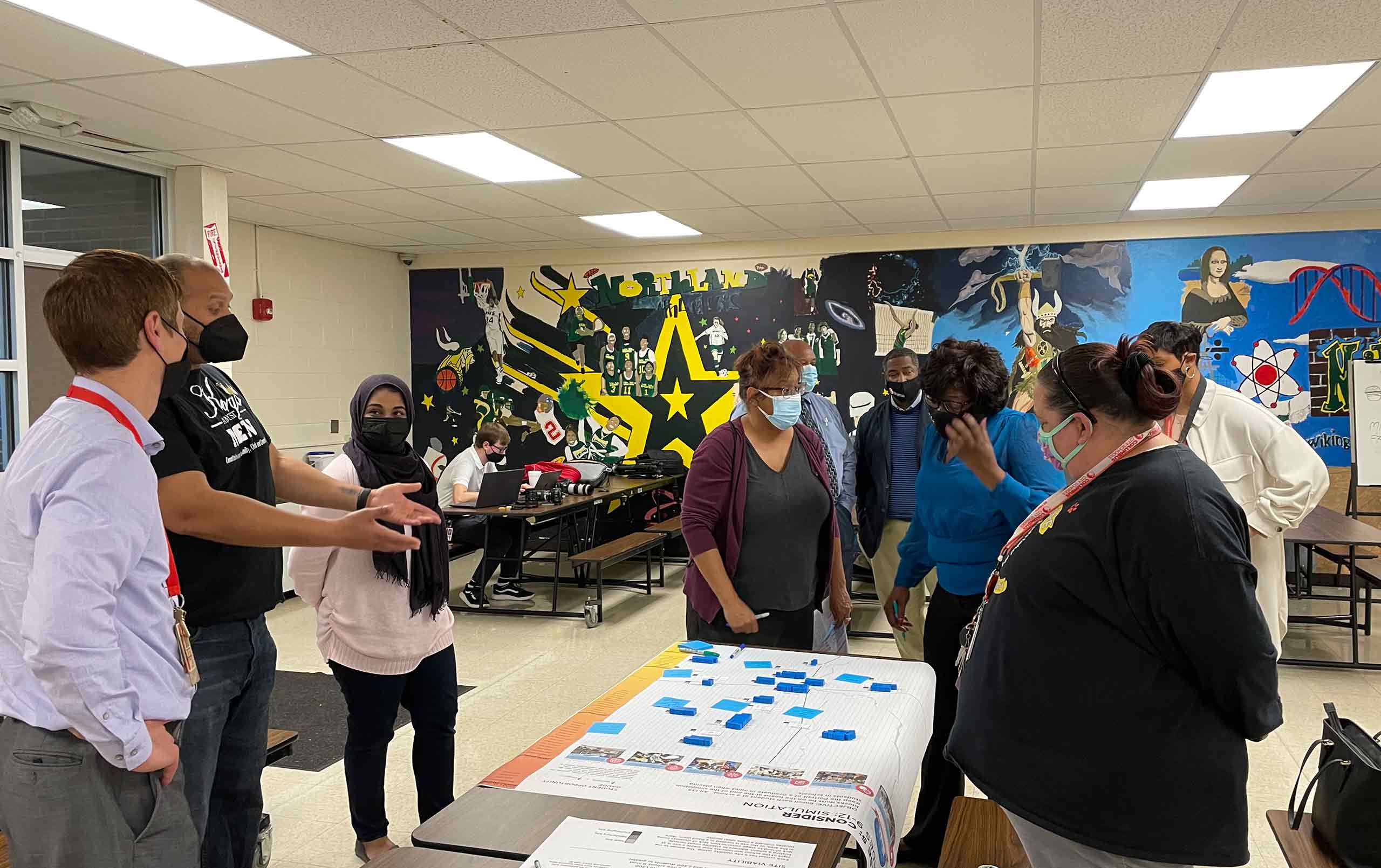 A group of faculty and staff collaborating in the cafeteria. 