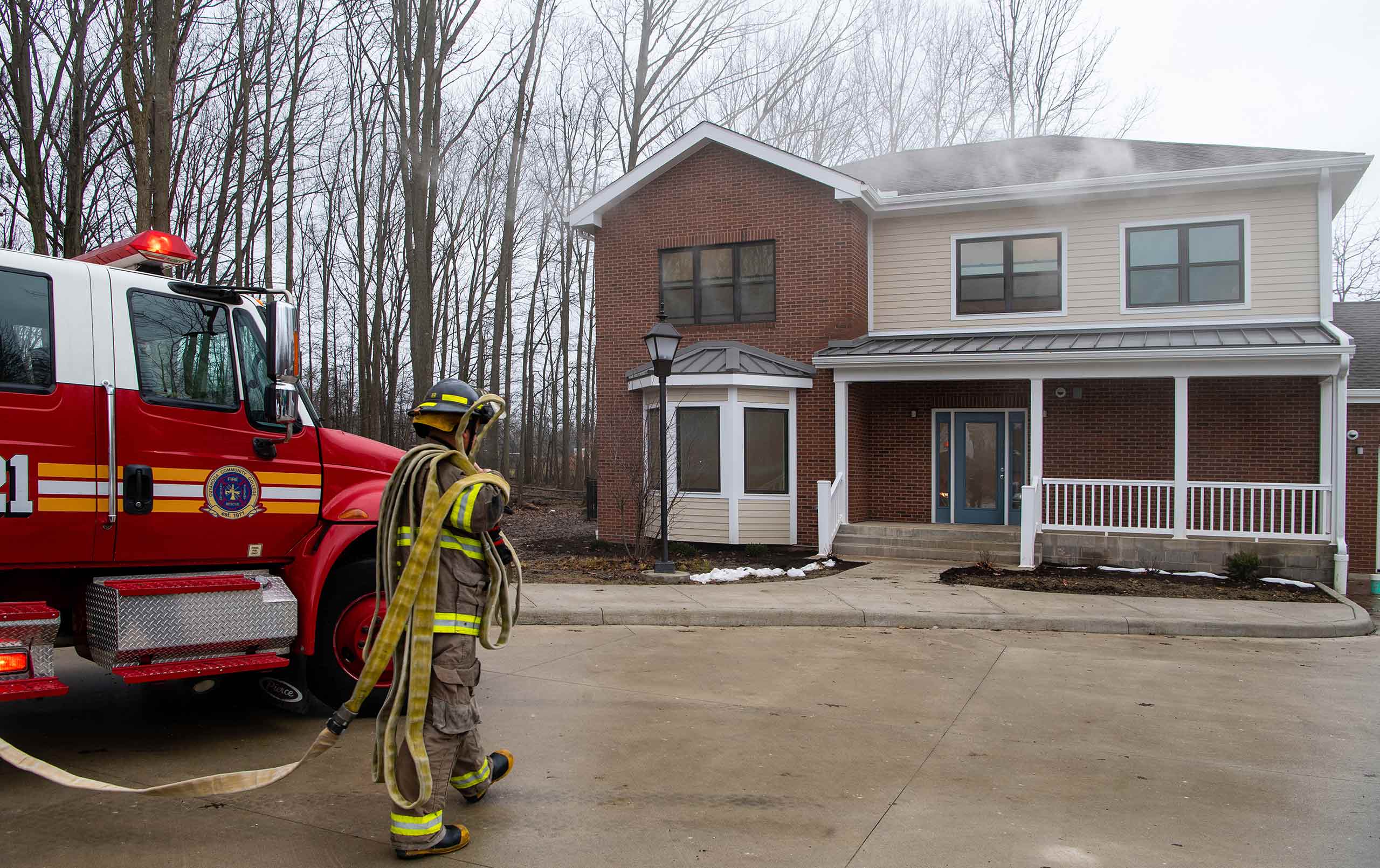 Firefighter trainee outside simulated house fire