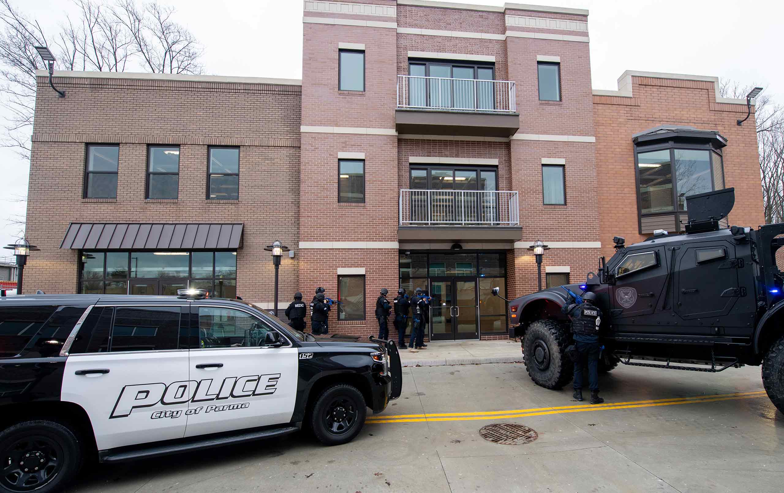 Officers and agents training outside of building as a simulation practice.