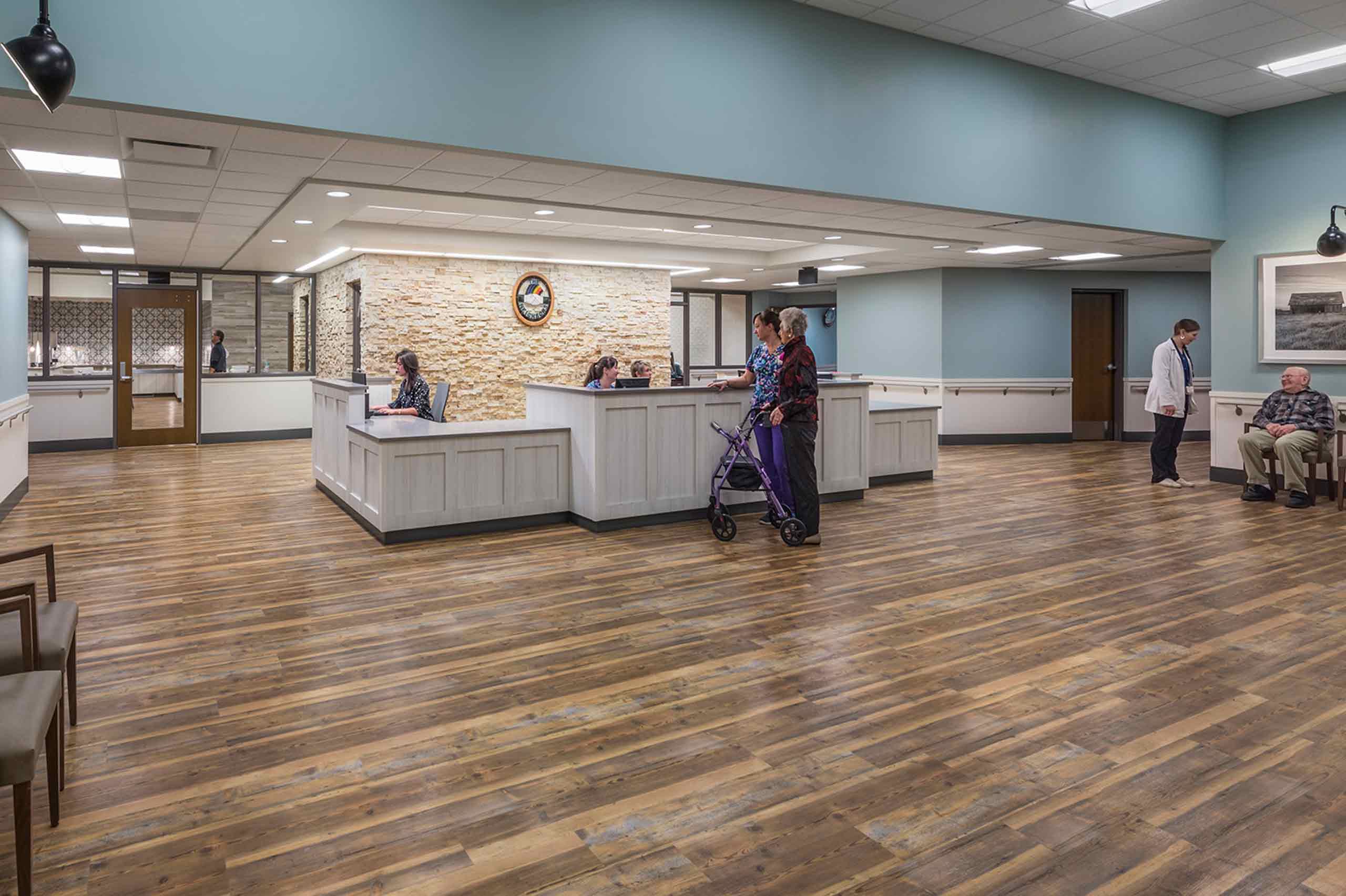 nurse with senior lady at front desk