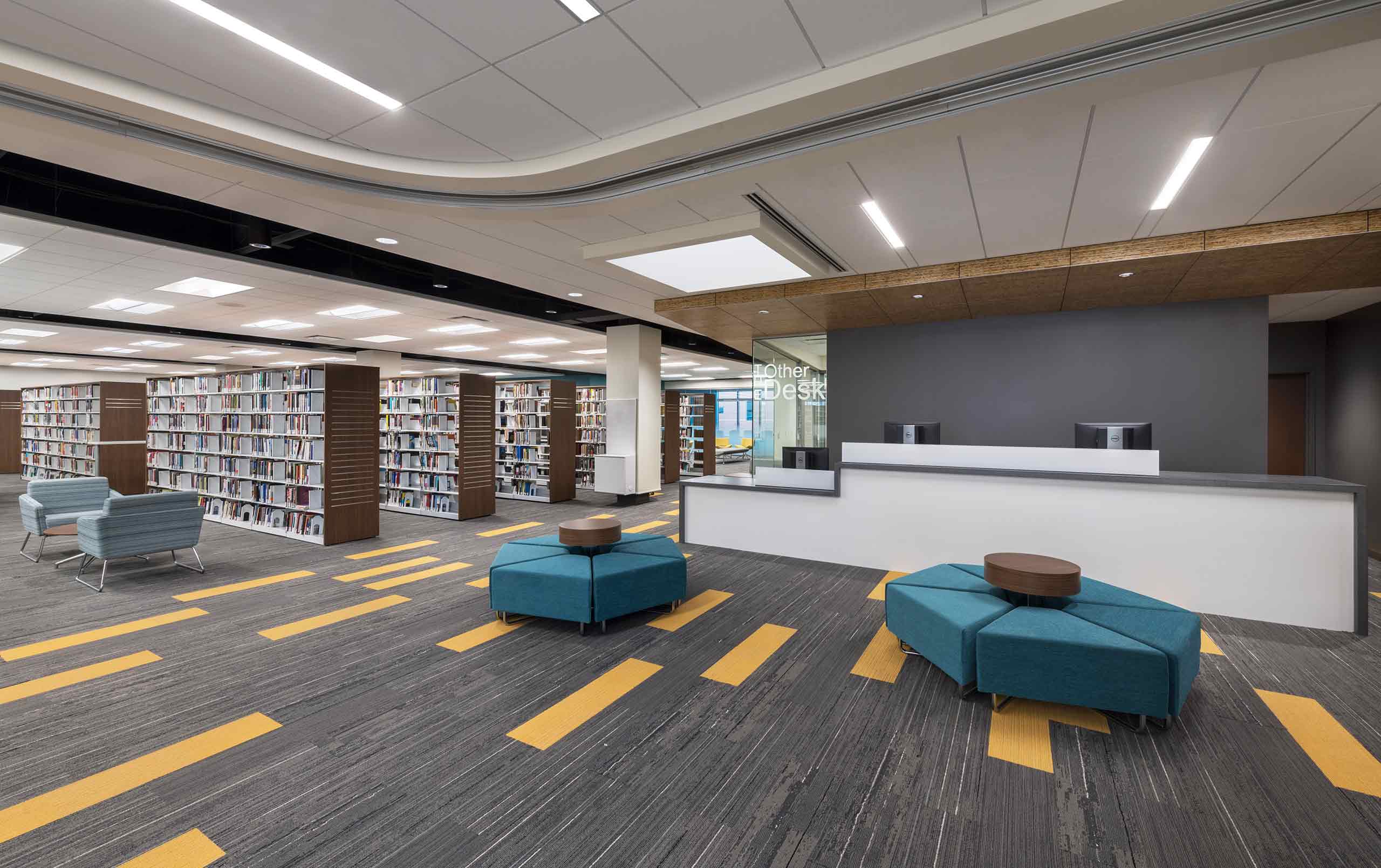 Seating area, bookshelves, and help desk at Harper Library.