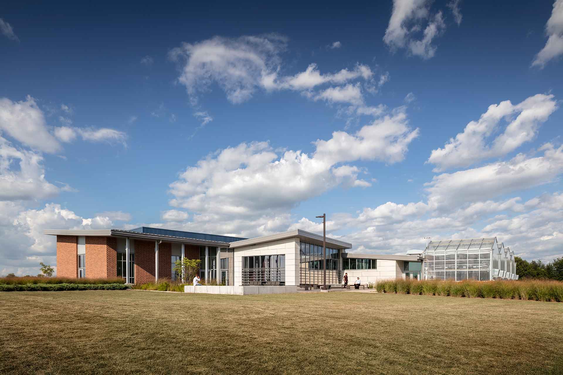 Daytime view of exterior of agricultural education facility with greenhouses