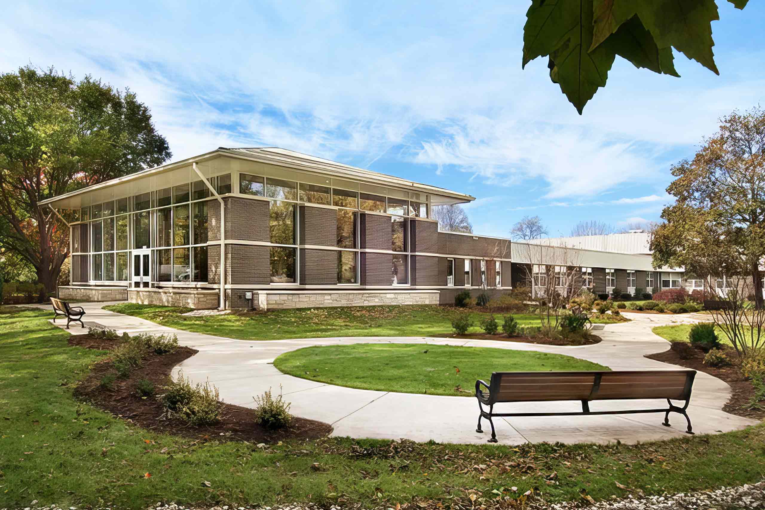 exterior senior facility building and park with bench