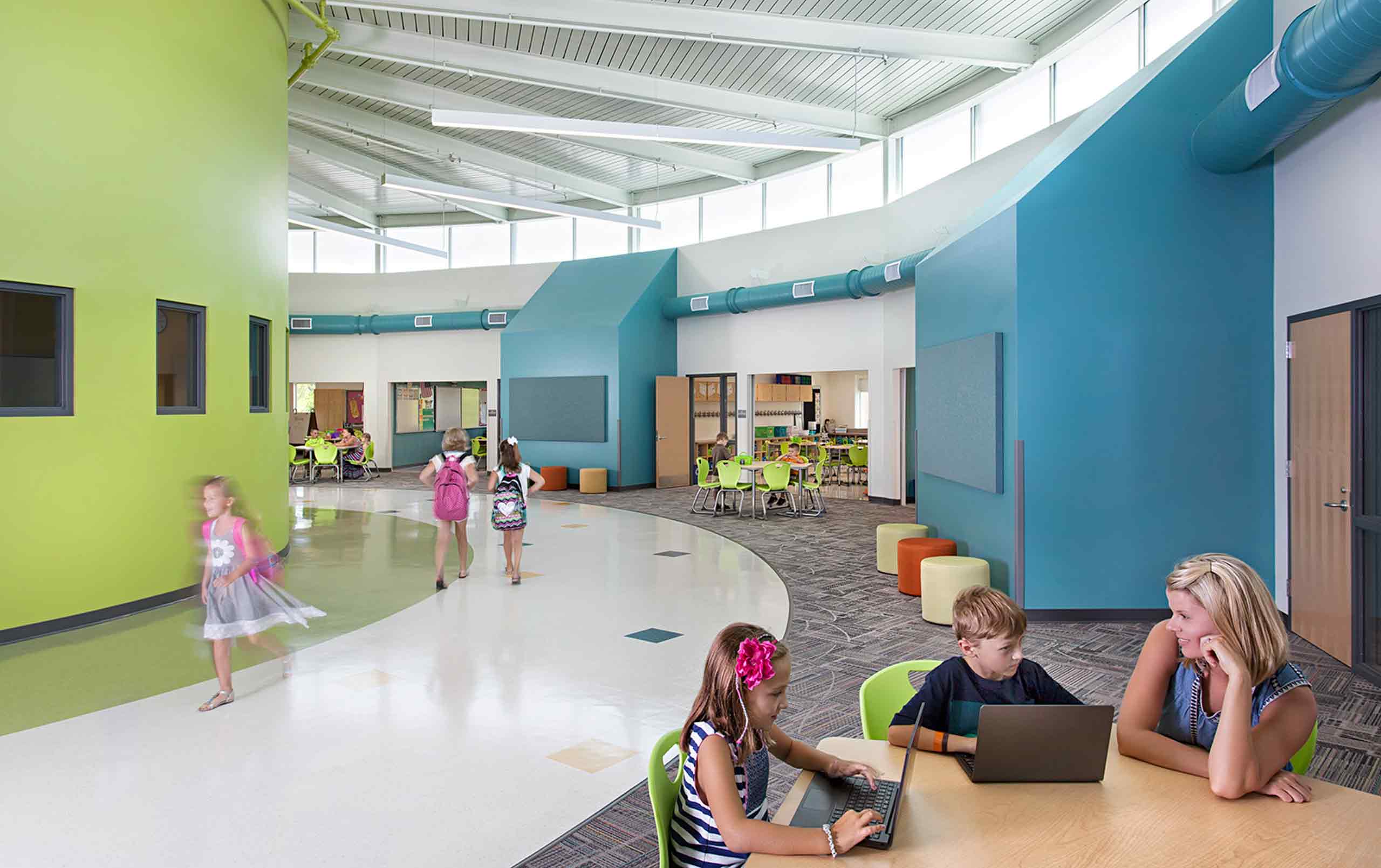 Hamilton Elementary School - children walking down the hall and teacher sitting with students in breakout space