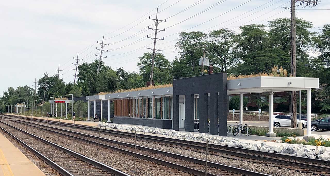 Railroad tracks in foreground and contemporary train station in background