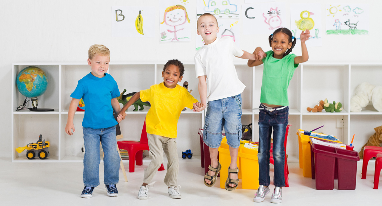 Kindergarten students holding hands and jumping