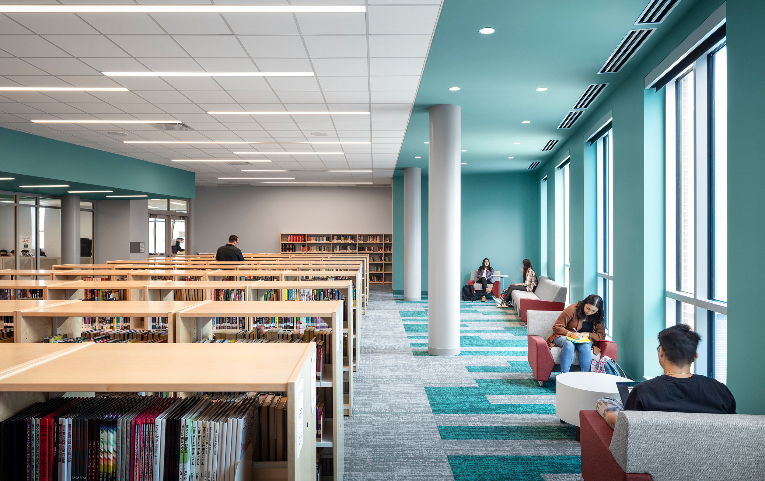 Library with students sitting next to windows