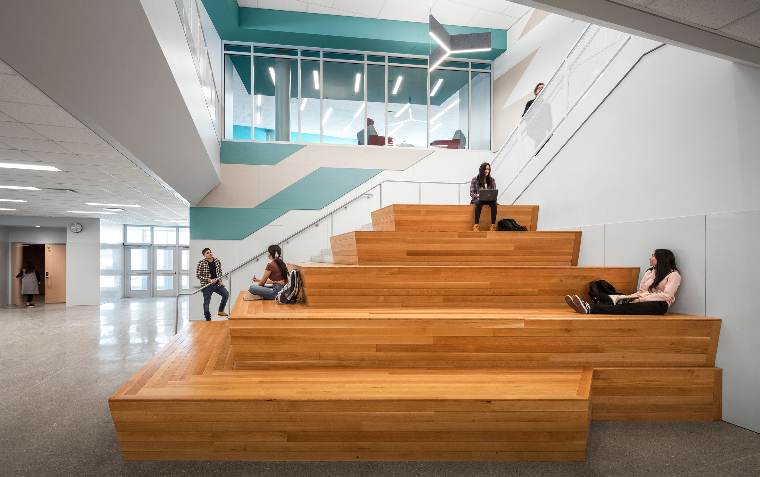 Students interacting on wooden staircase that leads to library