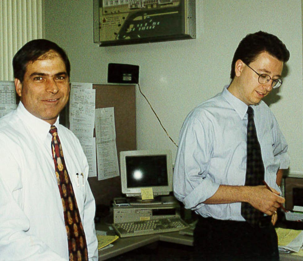 Architects in shirts and ties with old computer between them