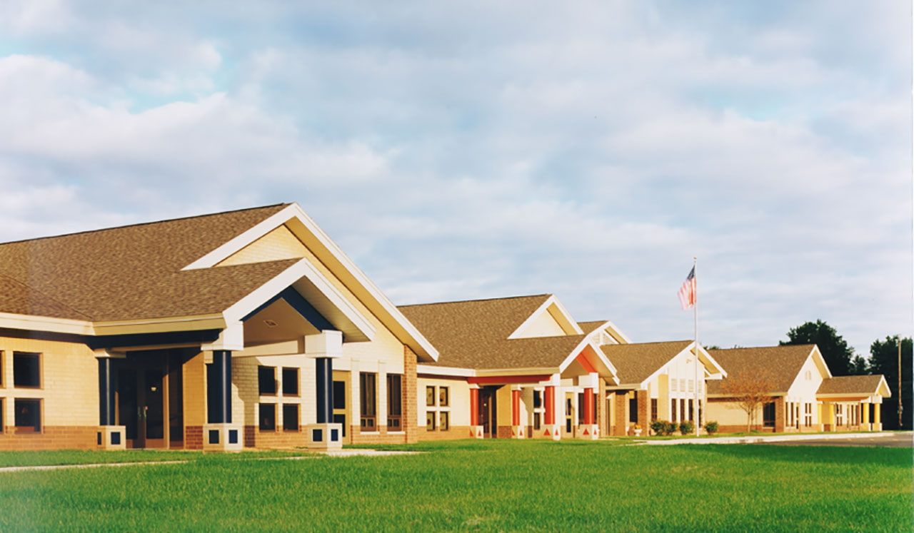 Exterior view of kindergarten center with peaked roofs and colored columns