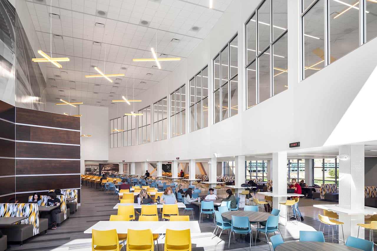 Cafeteria with booths and chairs, upper floor windows with views to lower floor