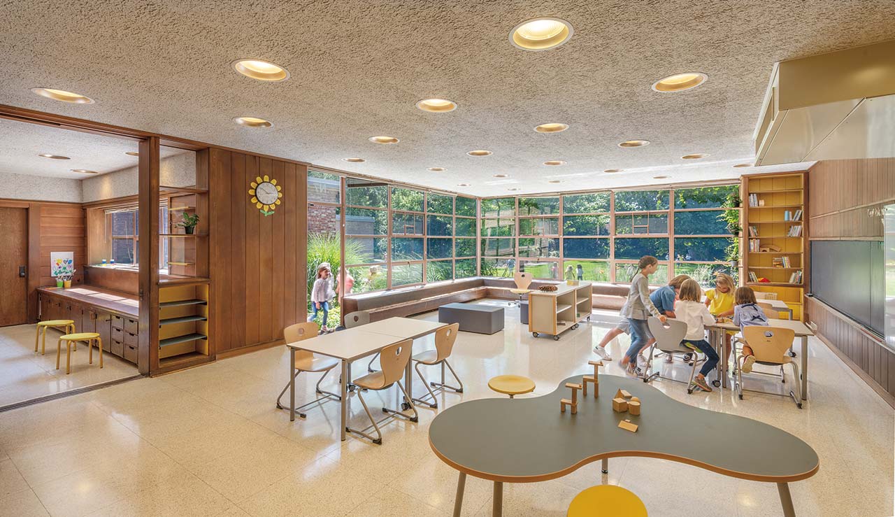 Students in classroom with windows displaying outdoor courtyard