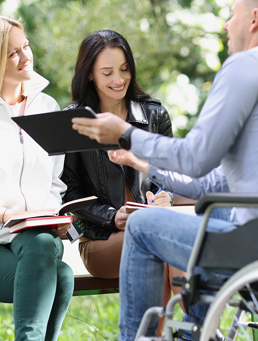 College student in wheelchair meeting with other students outside