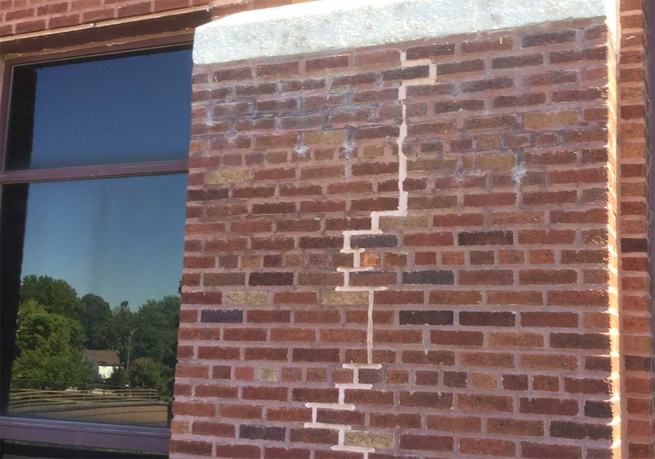 Brick wall with sealant used to patch settlement cracks