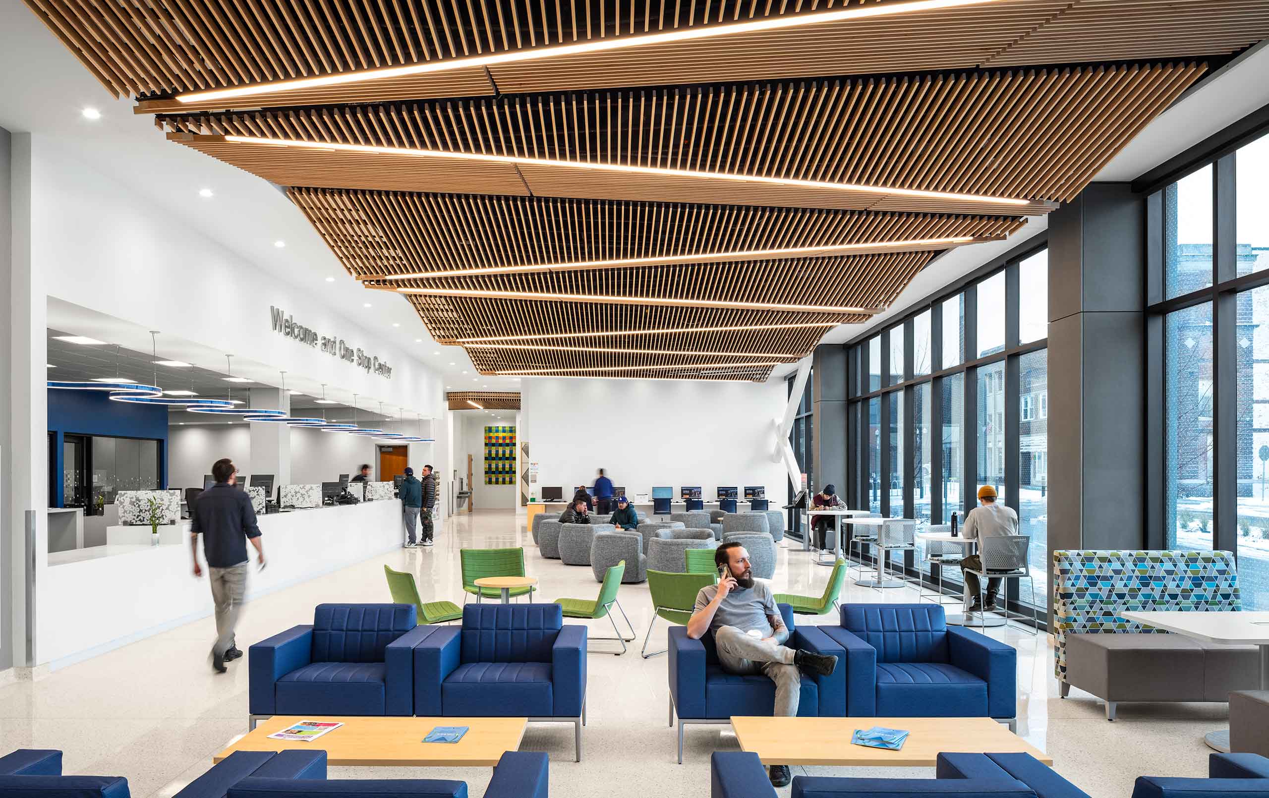 Community college welcome and one stop center with students sitting and getting information at reception desk