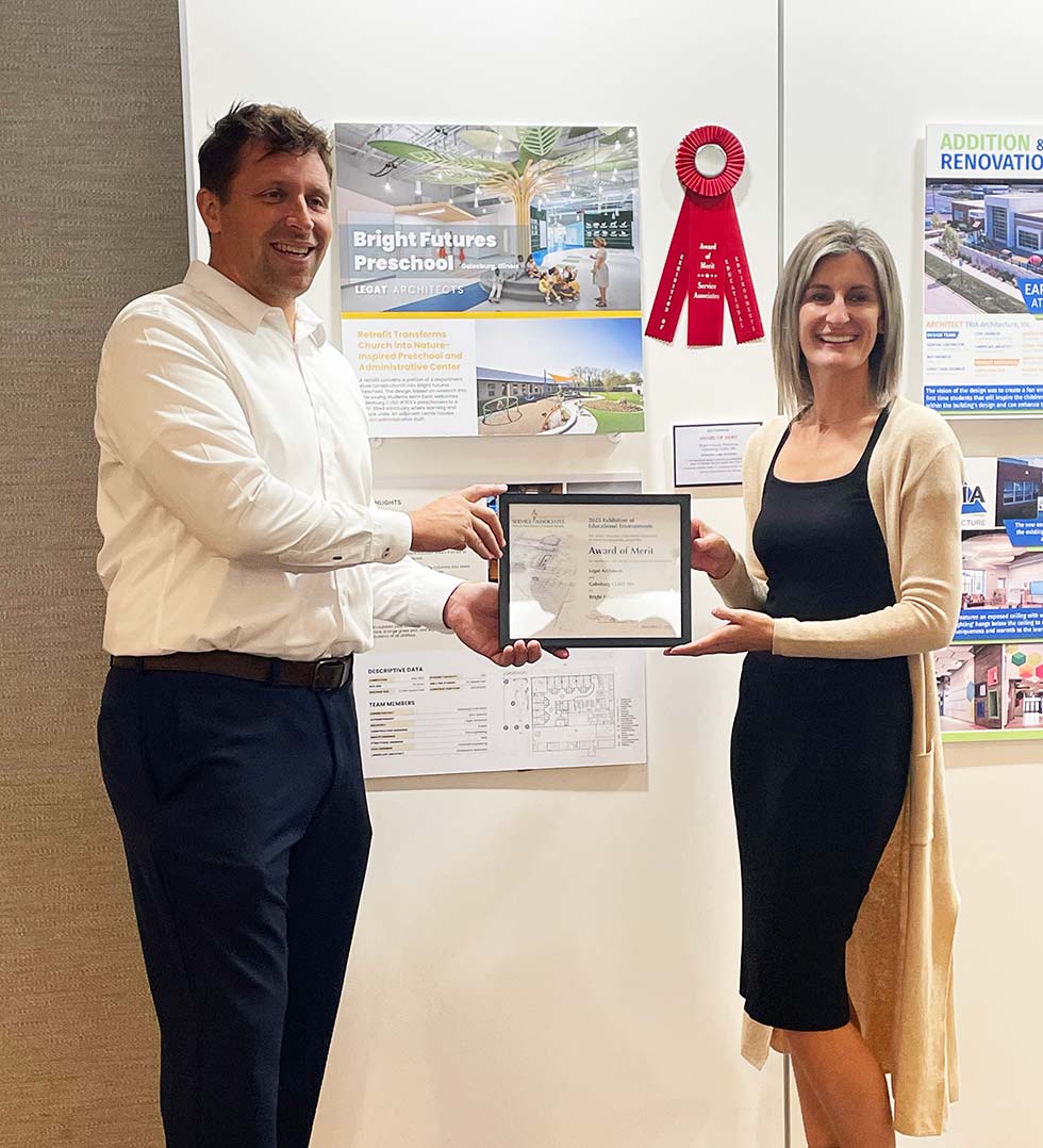 Architect and interior designer holding an award plaque