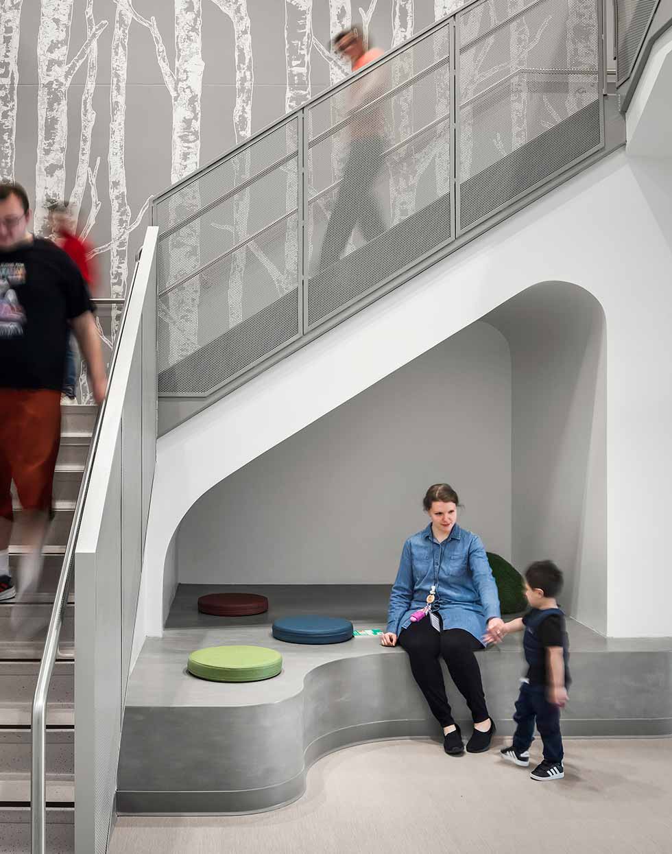 Teacher helping child beneath a staircase nook.