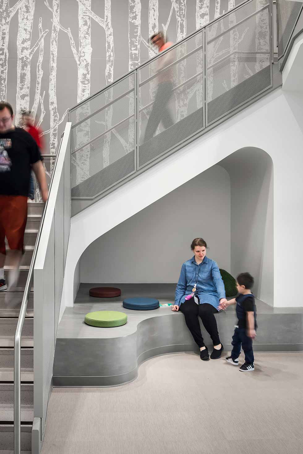 Teacher and early learning student in nook beneath stair
