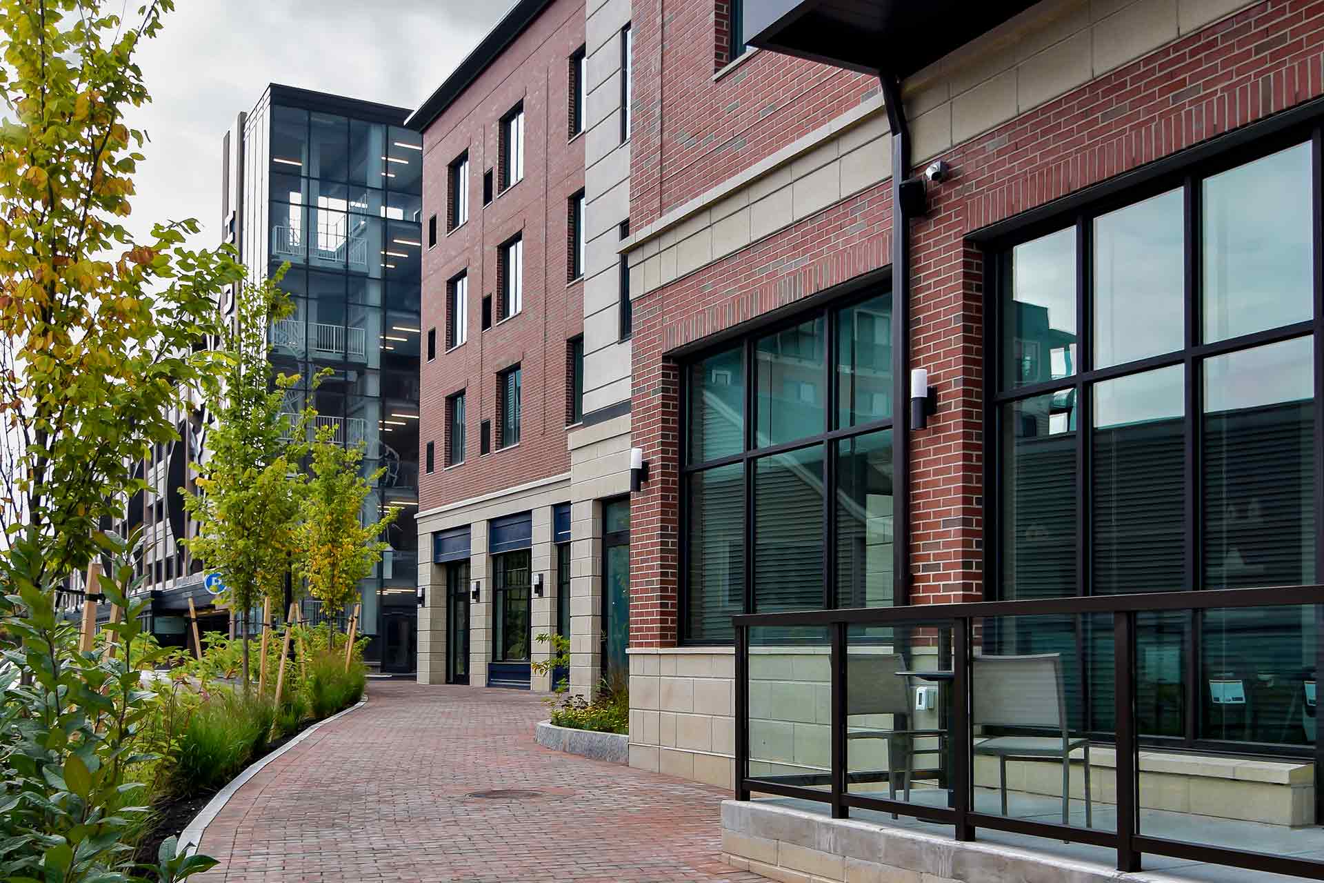 Street view of hotel with stair tower, windows displaying lobby, and outdoor seating area