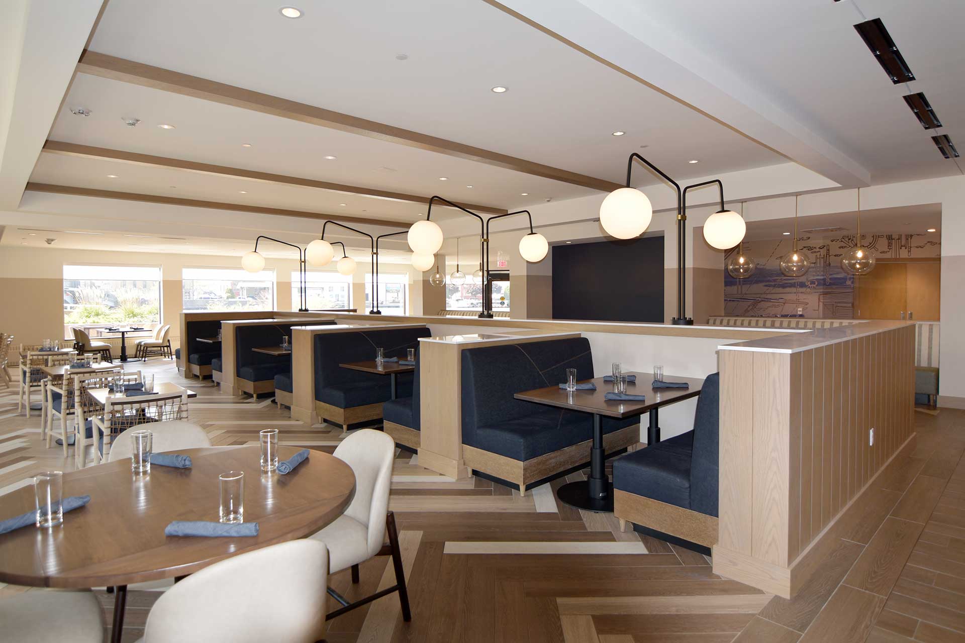 Hotel restaurant with table and booth seating, globe lighting