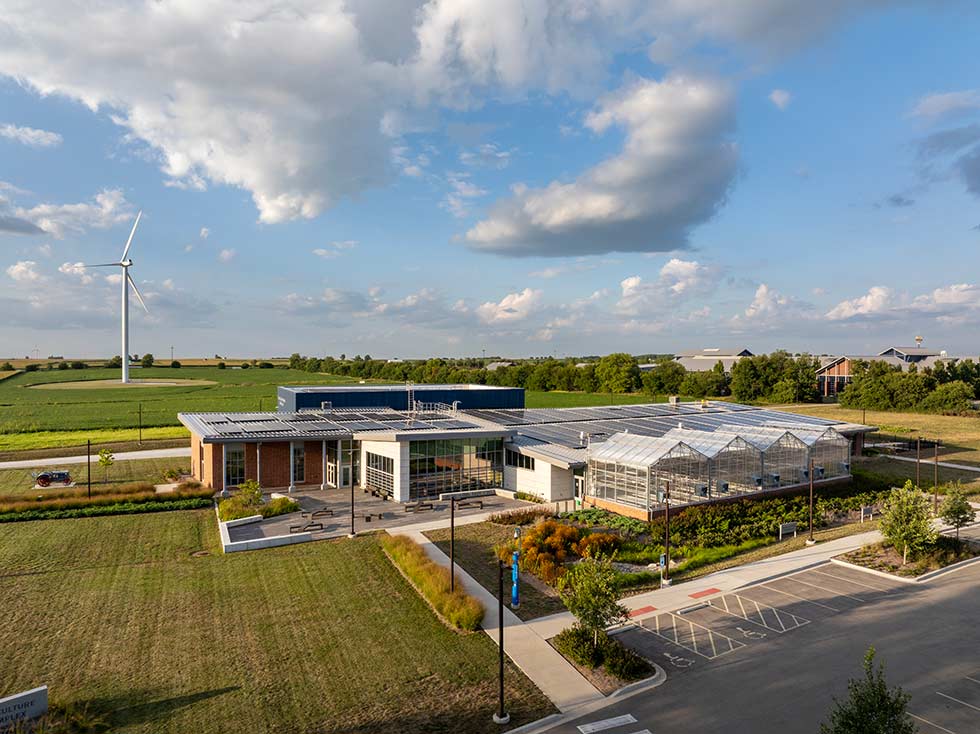 Aerial view of community college agriculture facility with wind turbine and solar panels