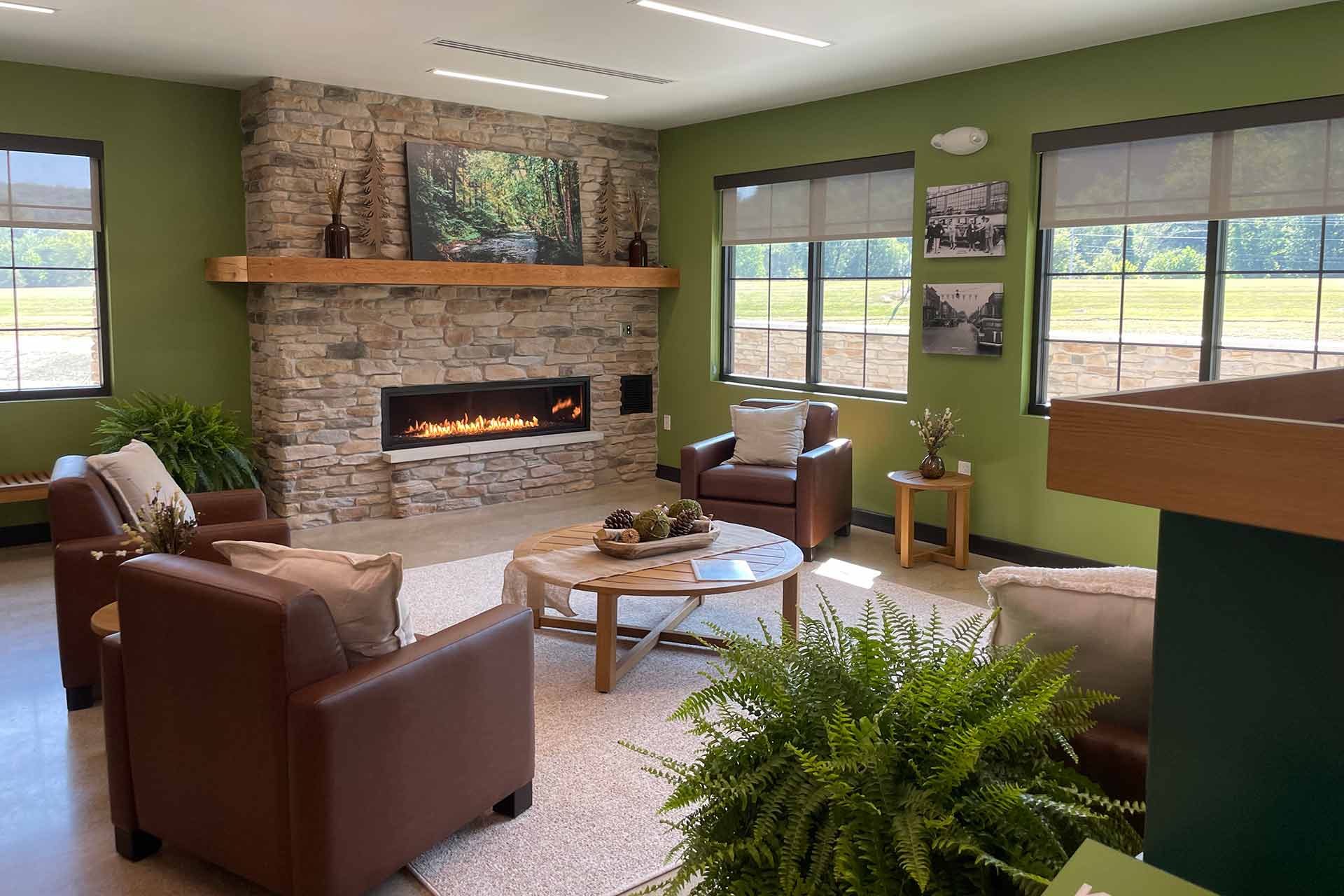 Cozy commons area with stone fireplace, seating, and windows