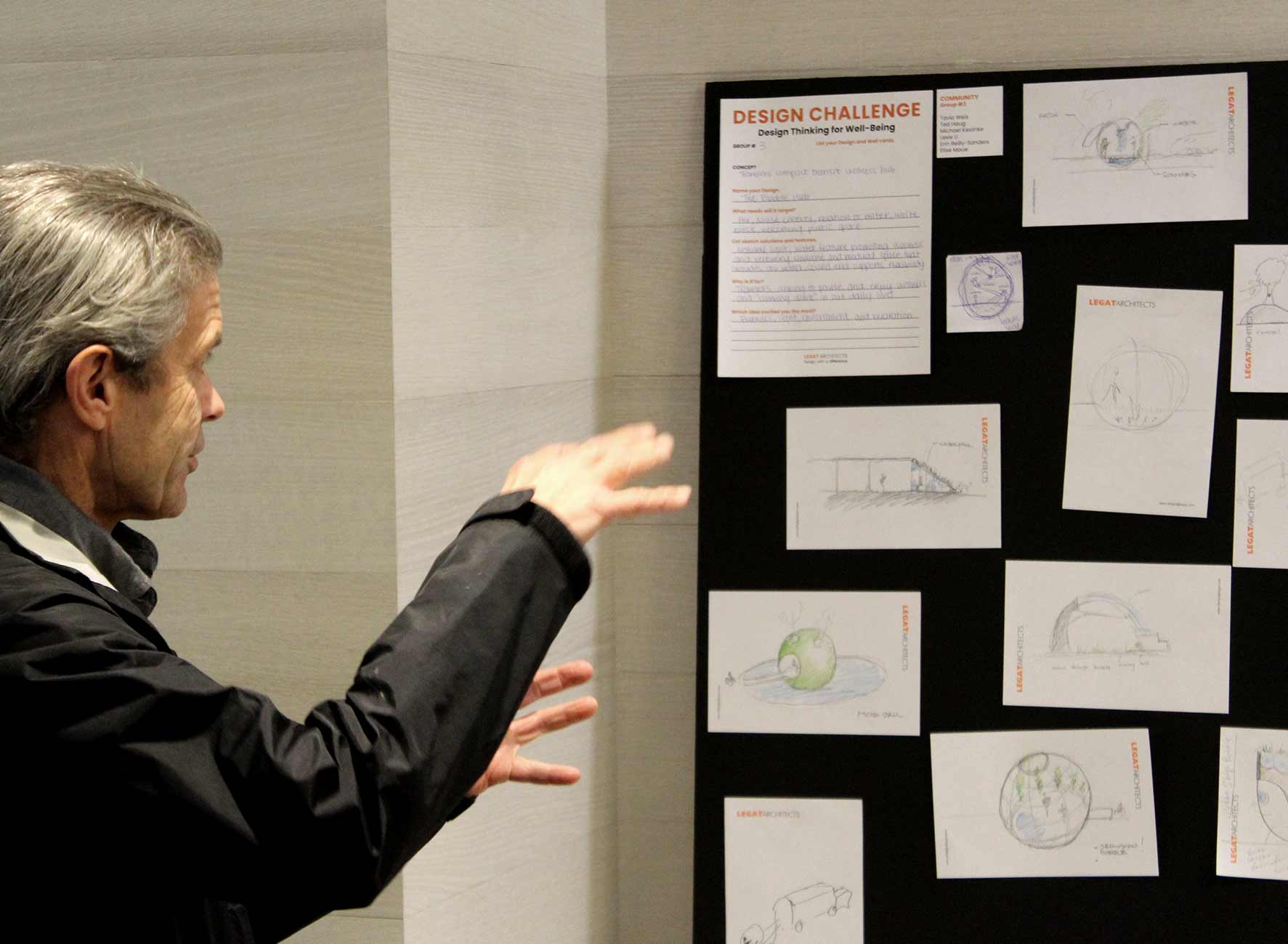 Participant presenting sketches and ideas on a Design Challenge board focused on design thinking for well-being.