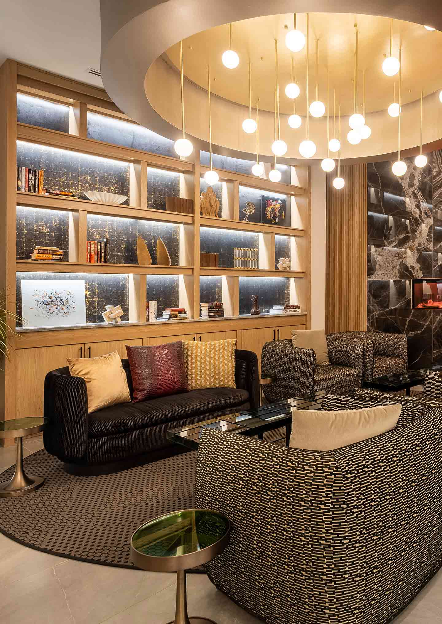 Hotel lobby guest seating with wooden bookshelf and pendant chandelier 