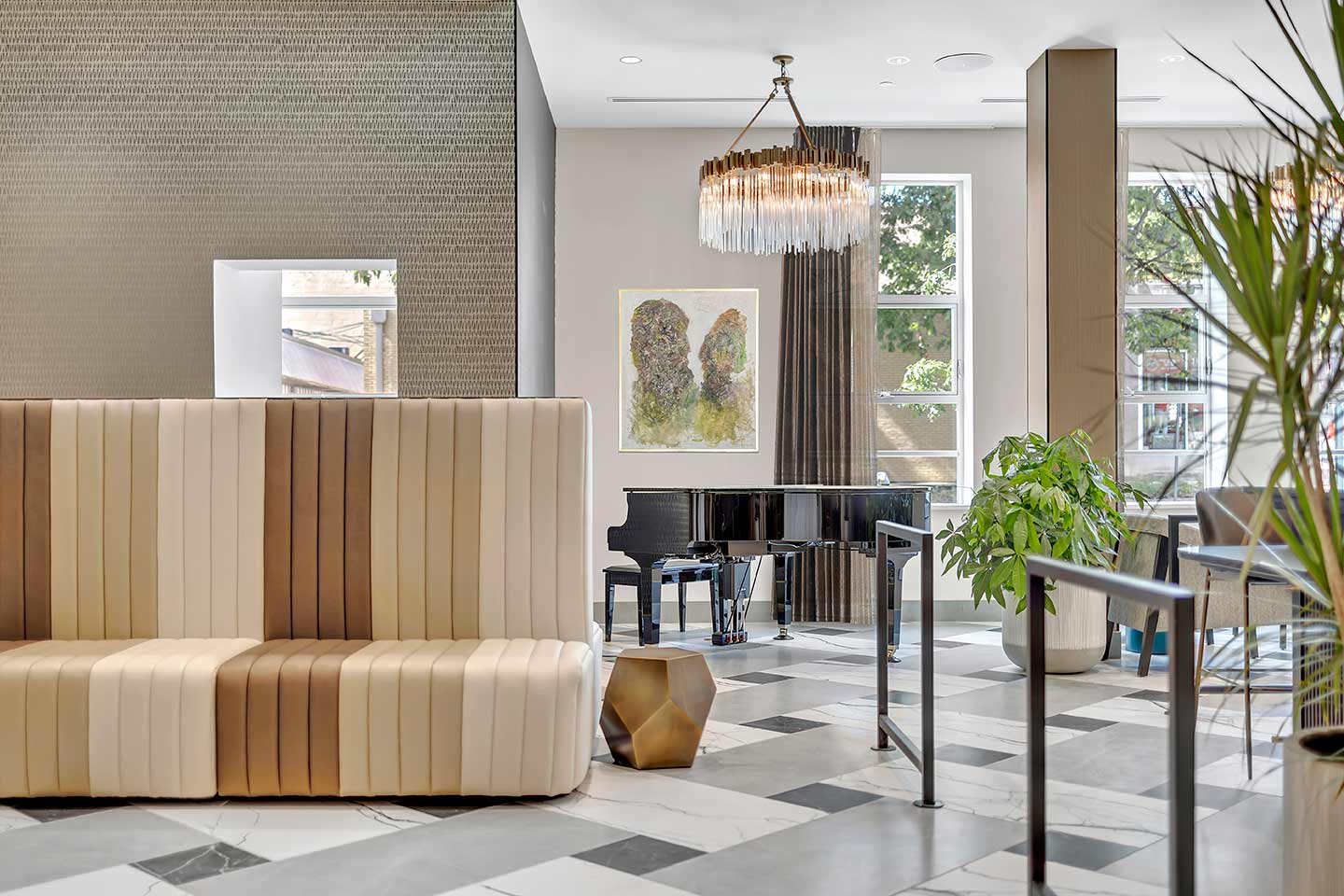 Hotel lobby with piano and contemporary couch with fluted design in varying shades of brown and tan