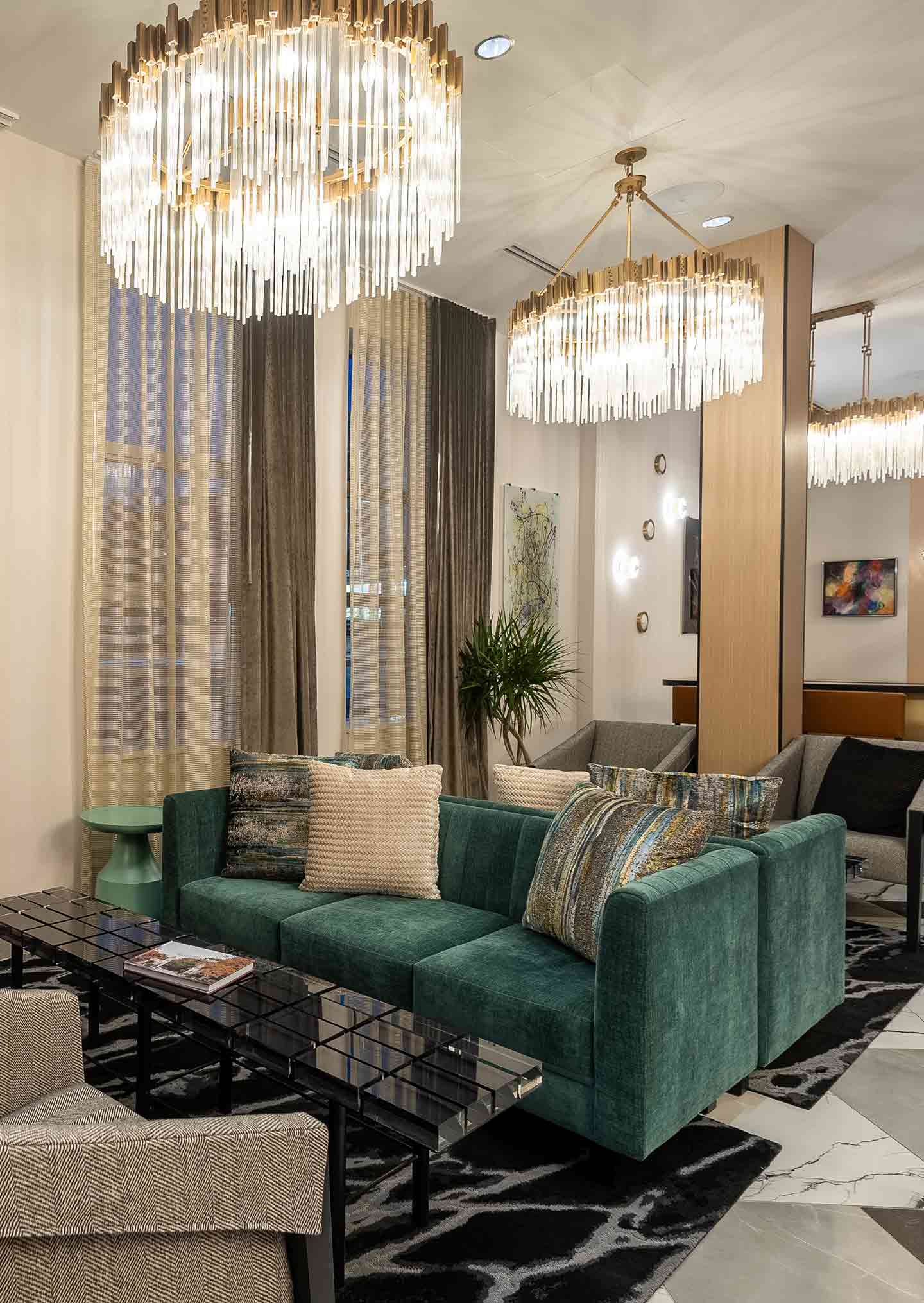 Hotel lobby with green sofas and chandeliers