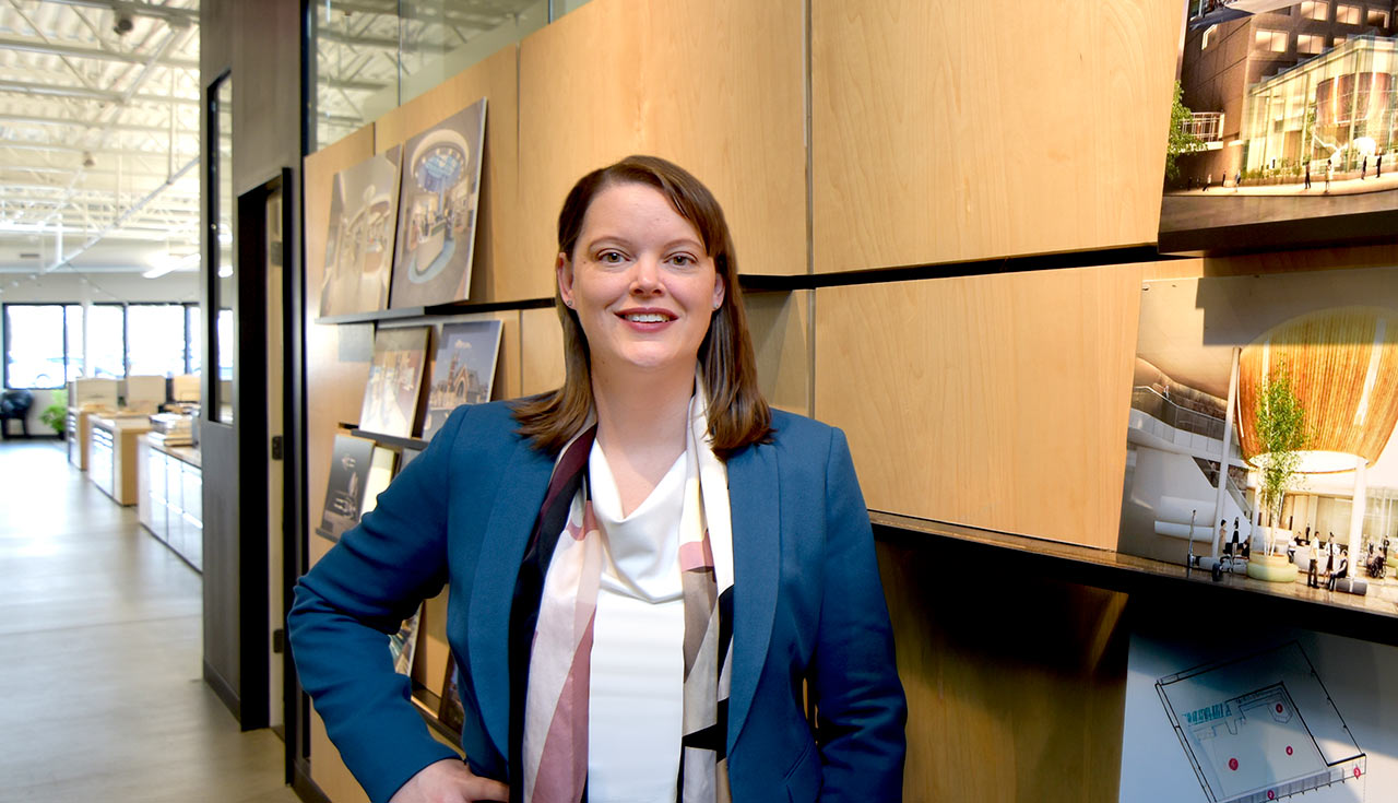 Female architect at studio with architectural images