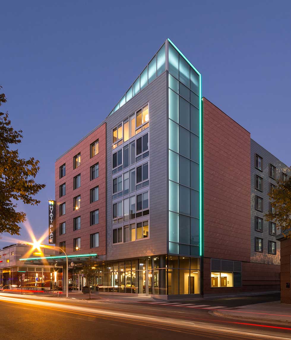 Night shot of hotel with illuminated fin and various materials