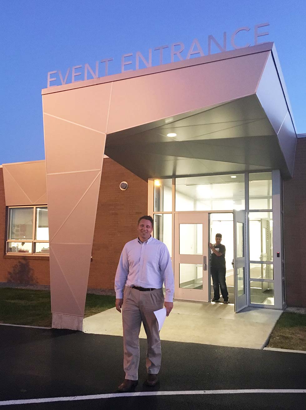Architect standing before modern school entry