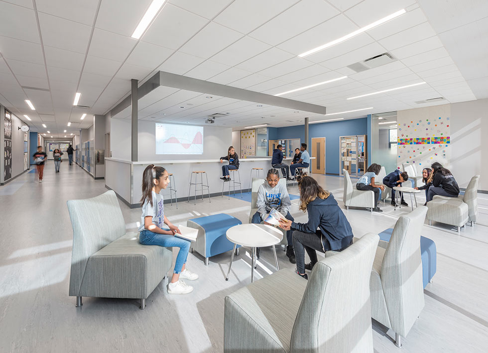 Middle school gathering garea with comfortable seating and high-top chairs