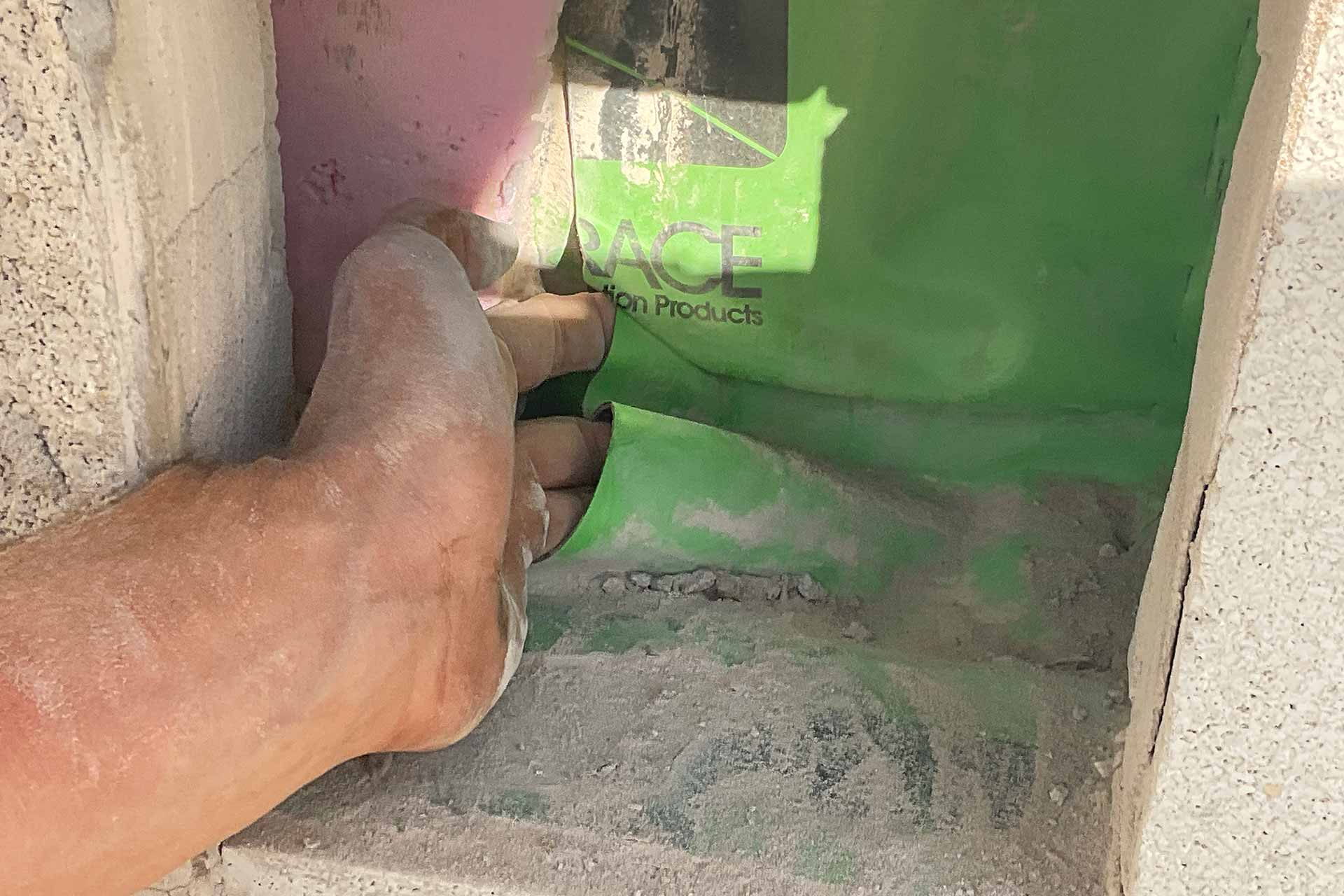 Contractor sticking hand into gap in flashing