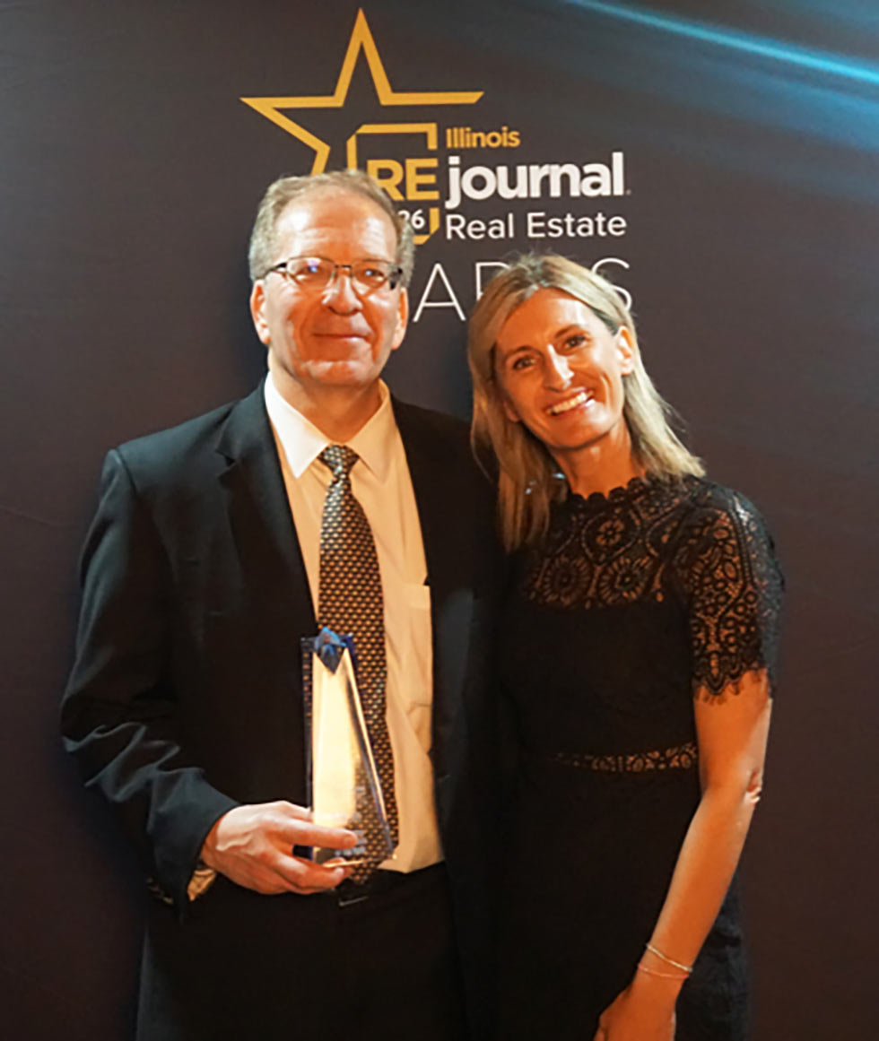 Male and female architect with trophy